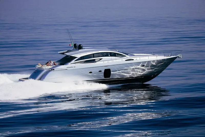 A silver hulled Pershing 72 holds a fast cruise on deep blue water.