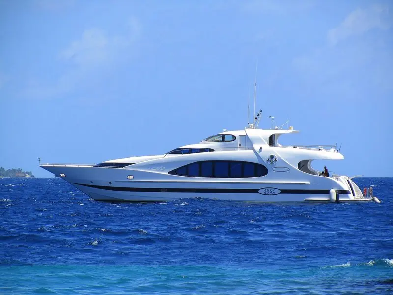 The custom-built motor yacht Arumaaz lying at anchor on deep blue water in the Maldives