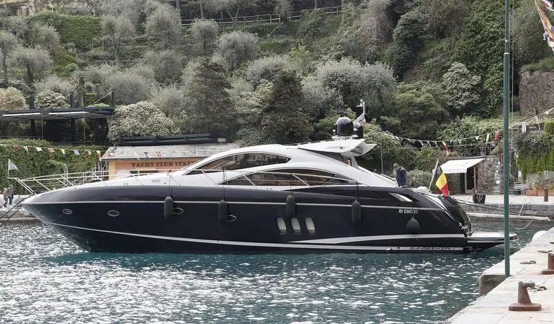 Bunting and olive trees frame a black Predator on the quay at Portofino.