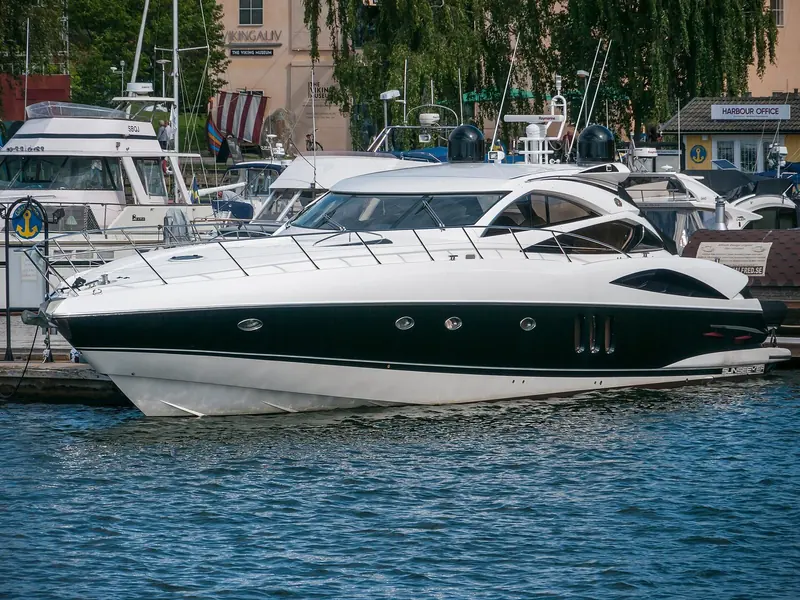 A black-hulled Sunseeker sits at her berth in Wasahamnen, Stockholm, hull lettering plain in the afternoon light.
